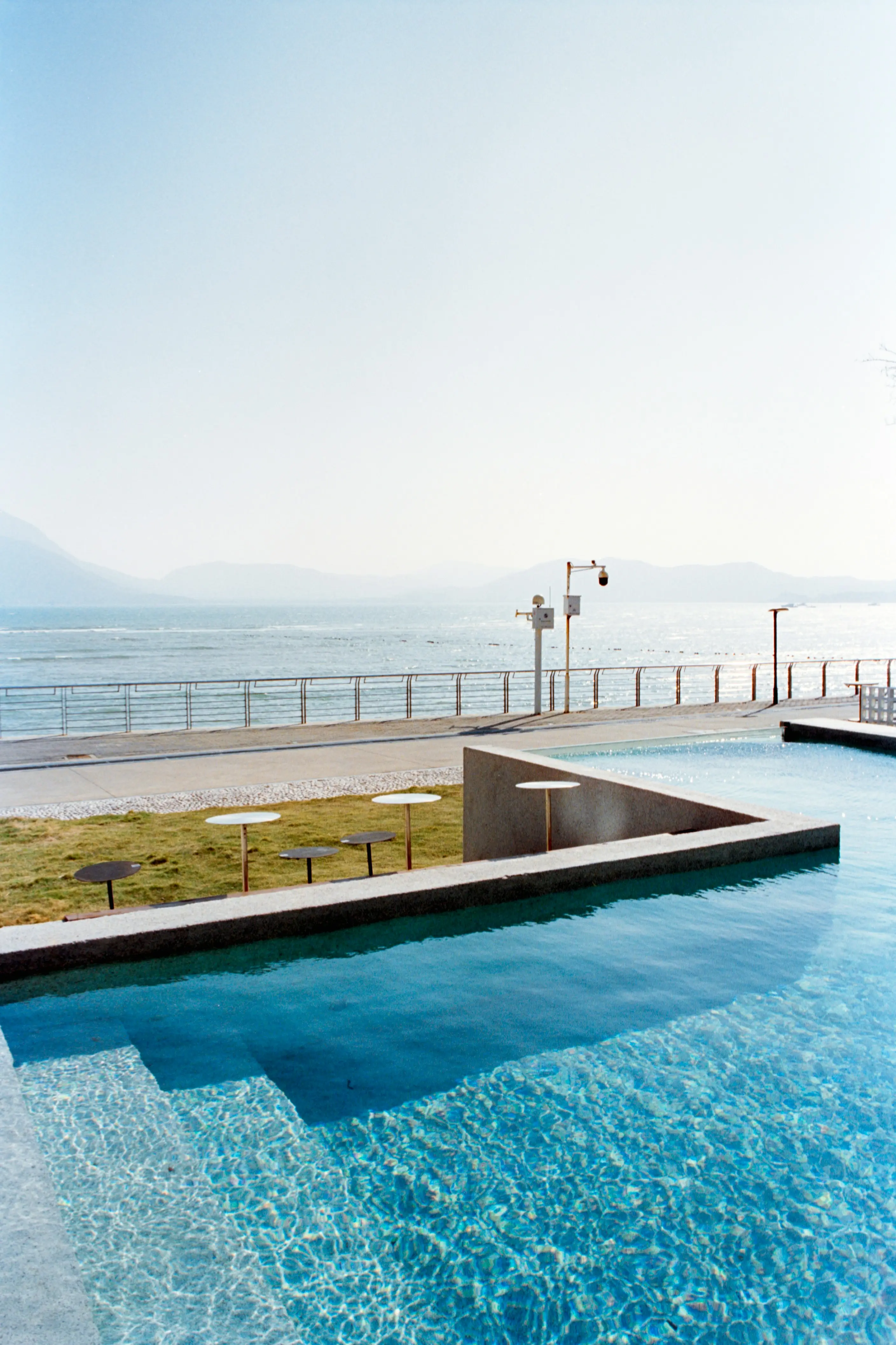 Luxury resort pool facing calm ocean and mountains